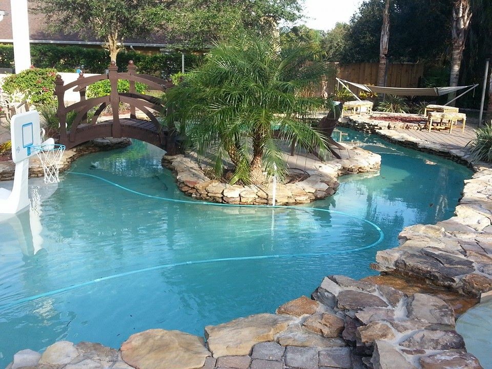 Modelo de piscina con fuente natural grande redondeada en patio trasero con adoquines de piedra natural