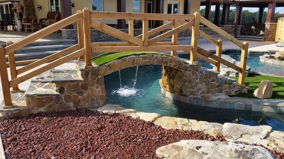 Imagen de piscina con fuente natural grande redondeada en patio trasero con adoquines de piedra natural
