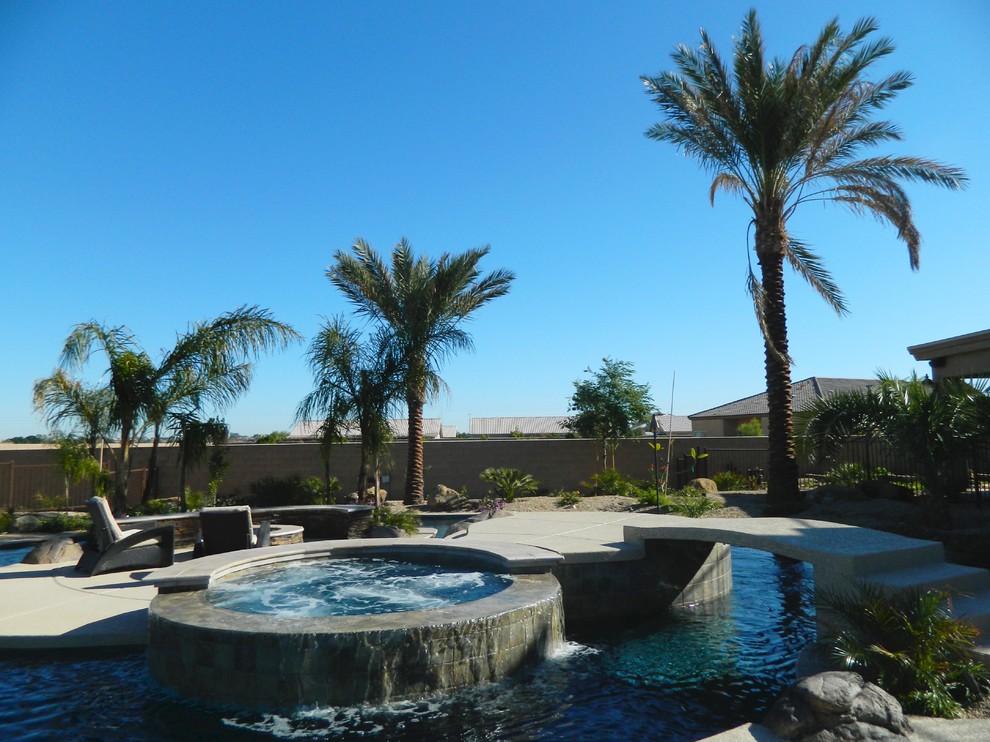 Пример оригинального дизайна: большой естественный бассейн произвольной формы на заднем дворе в средиземноморском стиле с покрытием из каменной брусчатки