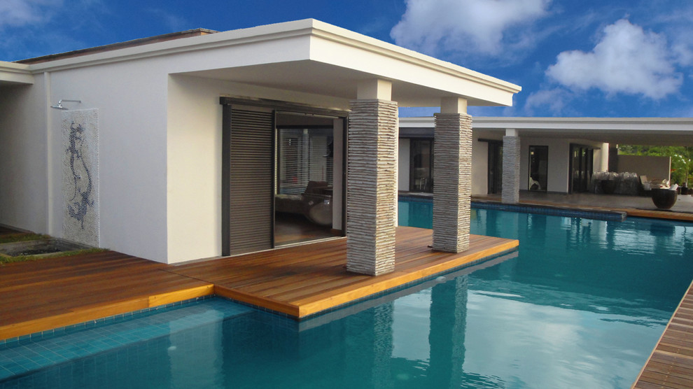 Esempio di una grande piscina monocorsia tropicale davanti casa con una dépendance a bordo piscina e piastrelle