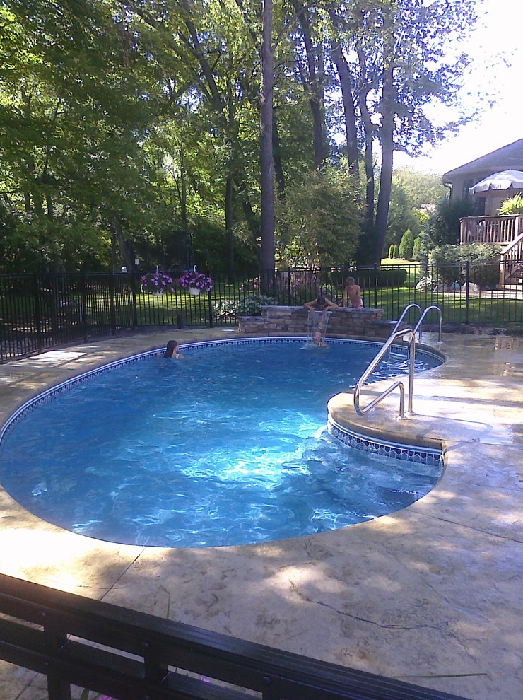 Imagen de piscina minimalista extra grande a medida en patio trasero con losas de hormigón