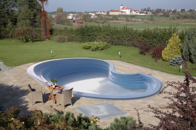 Diseño de piscina retro extra grande a medida en patio trasero con losas de hormigón