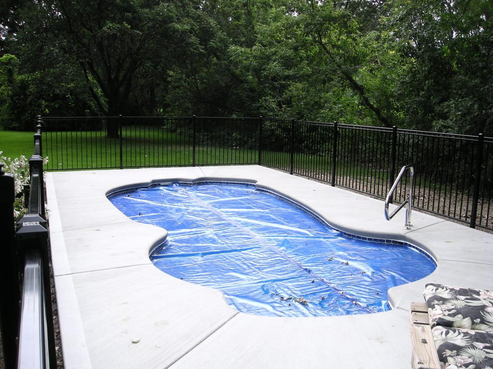 Design ideas for an expansive world-inspired back custom shaped swimming pool in Other with concrete slabs.