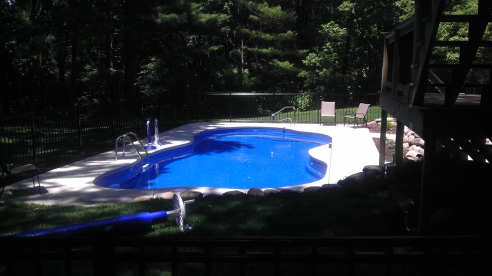 This is an example of an expansive modern back custom shaped swimming pool in Other with concrete slabs.