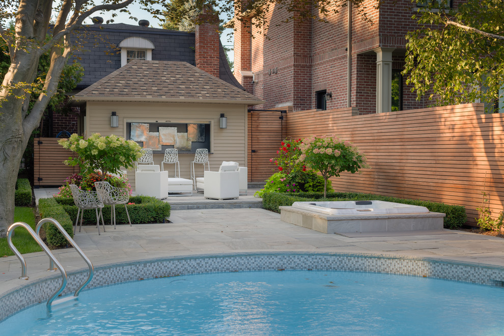 Immagine di una grande piscina monocorsia contemporanea rotonda dietro casa con una vasca idromassaggio e pavimentazioni in cemento