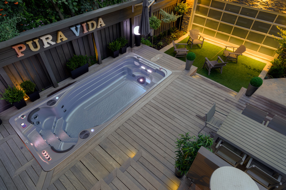 Идея дизайна: большой прямоугольный бассейн на заднем дворе в стиле модернизм с джакузи и настилом