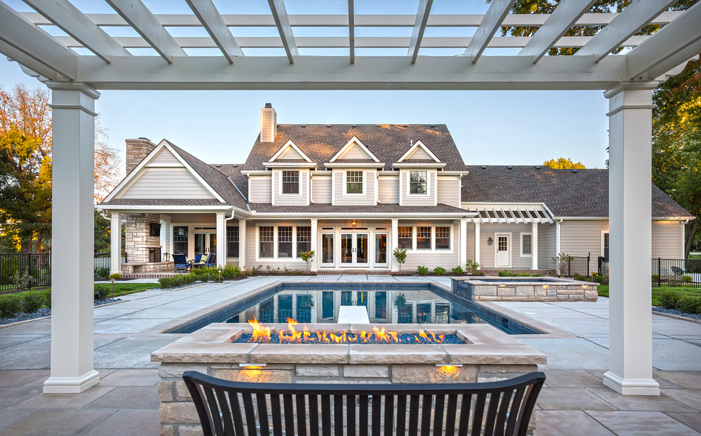 Idee per una grande piscina monocorsia tradizionale rettangolare dietro casa con una vasca idromassaggio e pavimentazioni in pietra naturale