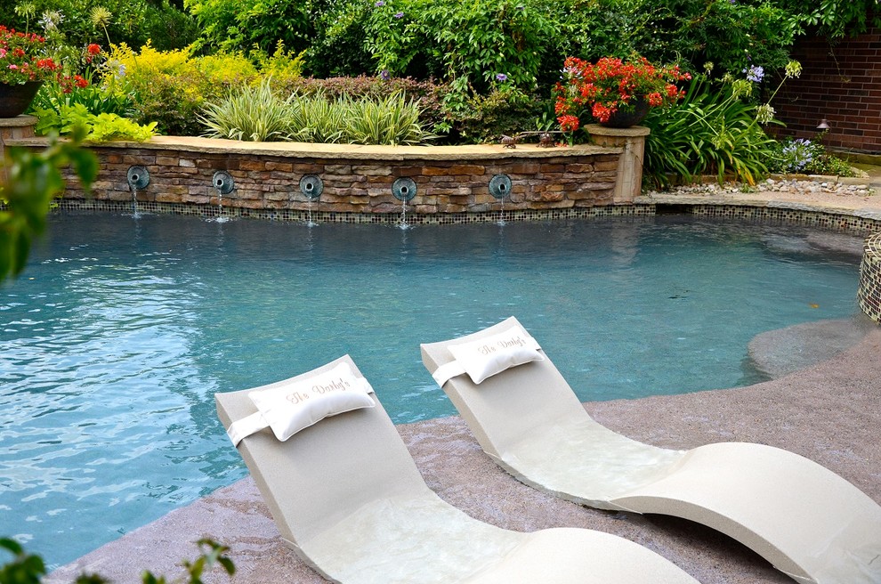 Design ideas for a contemporary back custom shaped lengths swimming pool in Houston with a water feature.