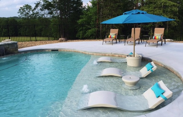 Modelo de piscina con fuente alargada contemporánea grande a medida en patio trasero con losas de hormigón