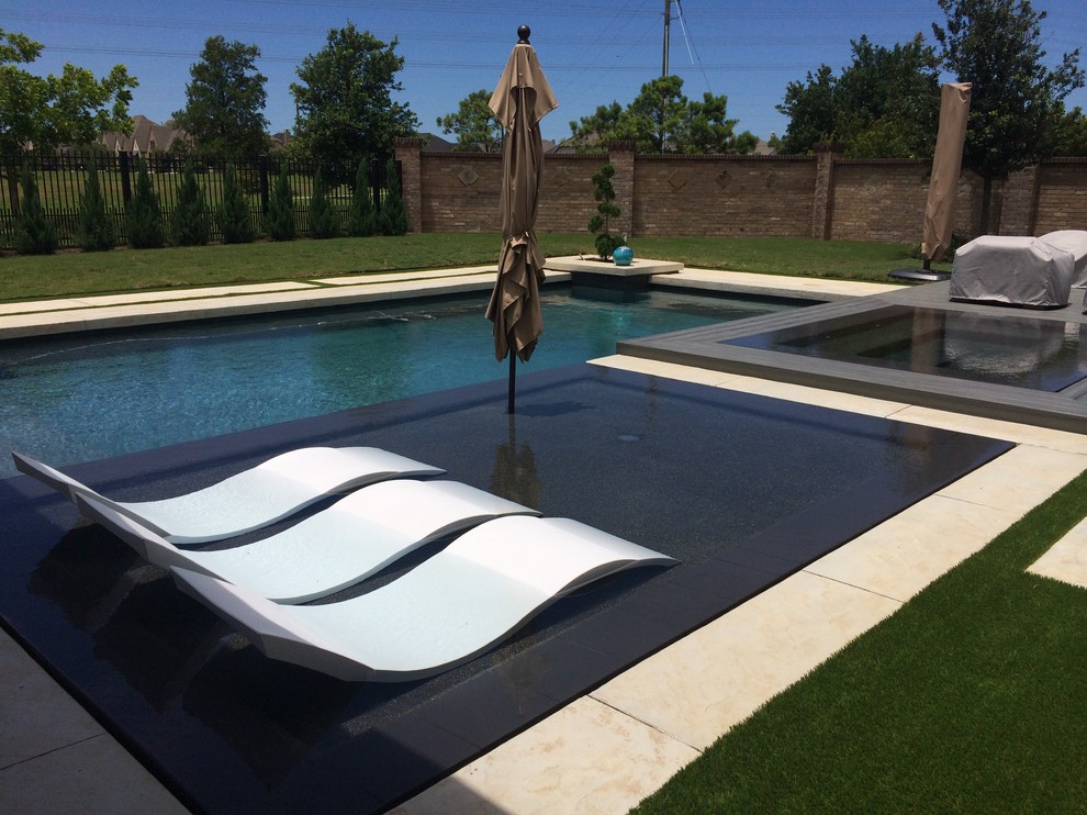 Modelo de piscinas y jacuzzis alargados actuales grandes rectangulares en patio trasero con suelo de baldosas