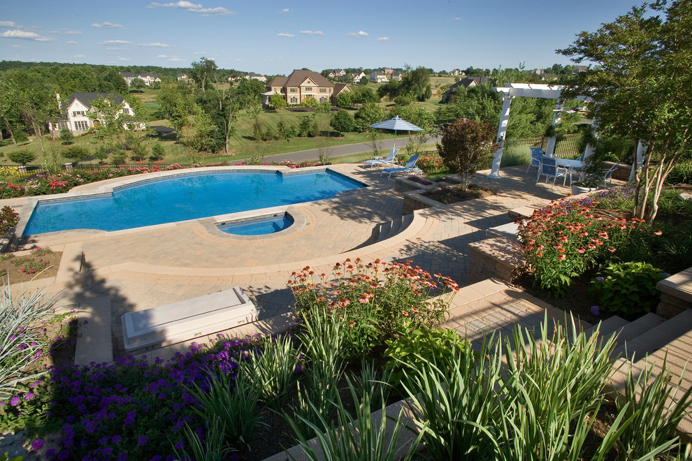 Ejemplo de piscina con fuente natural clásica de tamaño medio a medida en patio lateral con adoquines de hormigón