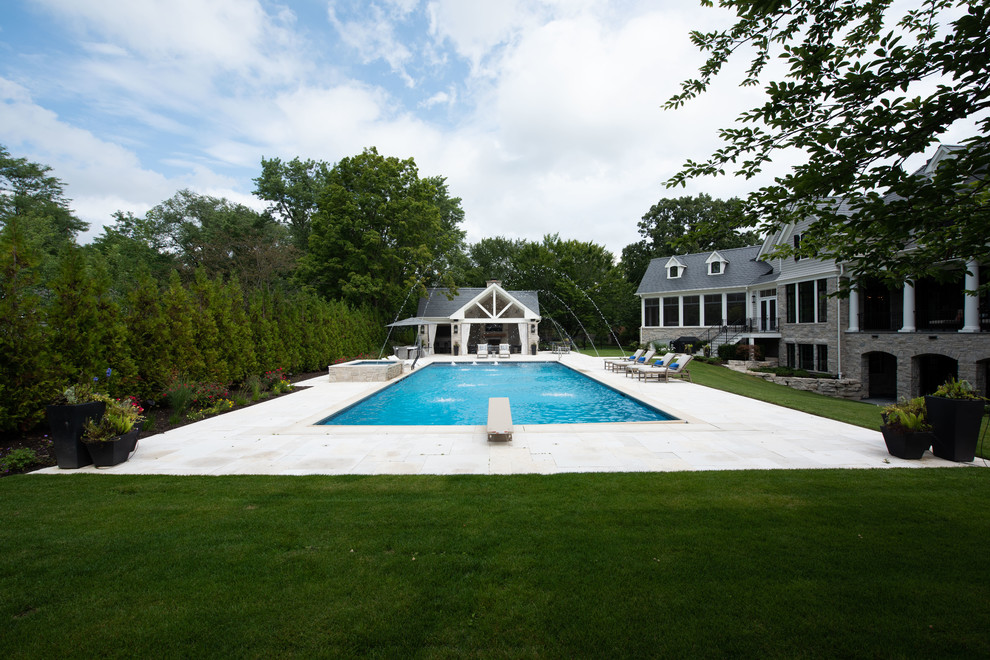 Modelo de piscina con fuente clásica grande rectangular en patio trasero con adoquines de piedra natural