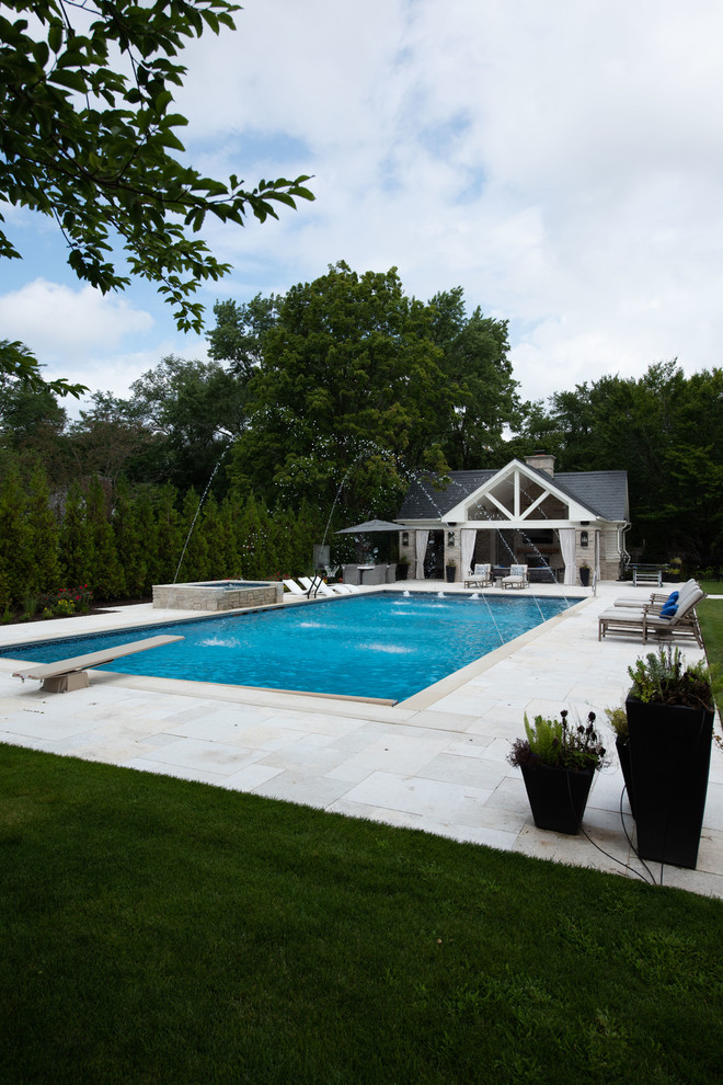 Großer Klassischer Pool hinter dem Haus in rechteckiger Form mit Wasserspiel und Natursteinplatten in Chicago