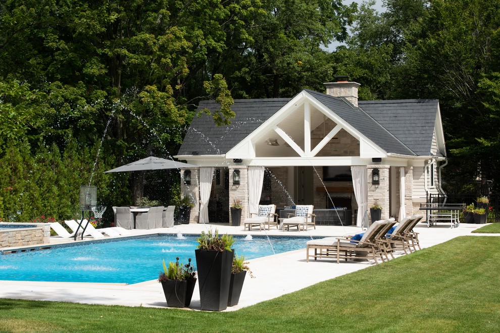 Example of a large classic backyard stone and rectangular pool house design in Chicago