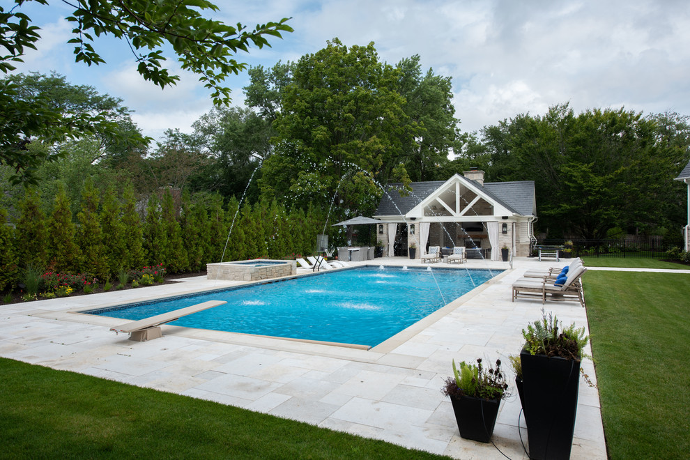 Diseño de piscina con fuente clásica grande rectangular en patio trasero con adoquines de piedra natural