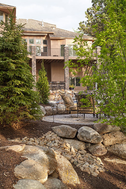 Inspiration for a backyard stone and custom-shaped pool house remodel in Omaha