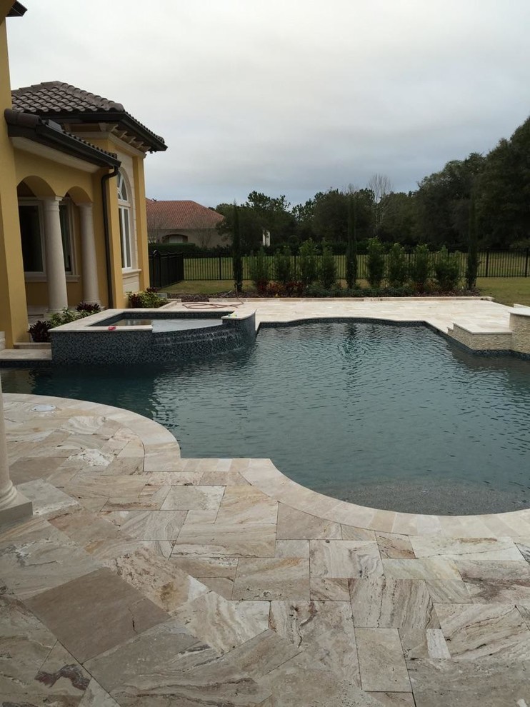 Foto de piscina con fuente alargada retro de tamaño medio a medida en patio con adoquines de piedra natural