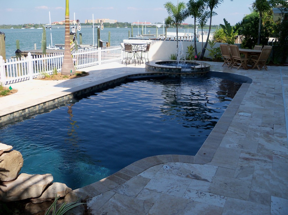 Diseño de piscina con fuente alargada retro de tamaño medio a medida en patio trasero con adoquines de piedra natural