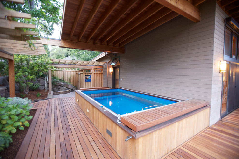 Ejemplo de piscina alargada contemporánea grande rectangular en patio lateral con entablado