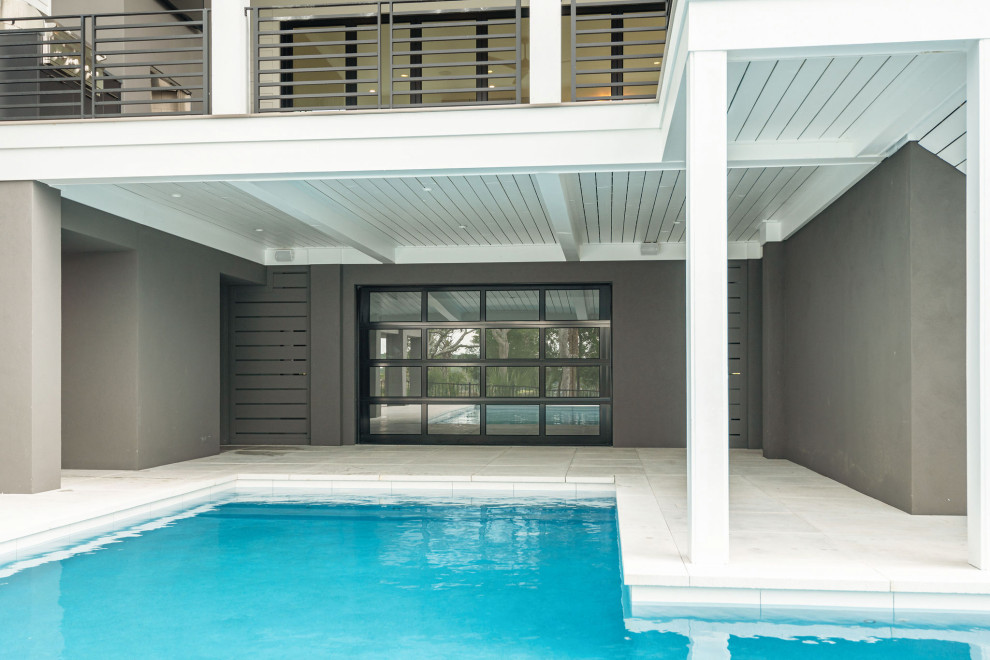 Großer Moderner Pool hinter dem Haus in L-Form mit Sichtschutz und Betonboden in Charleston
