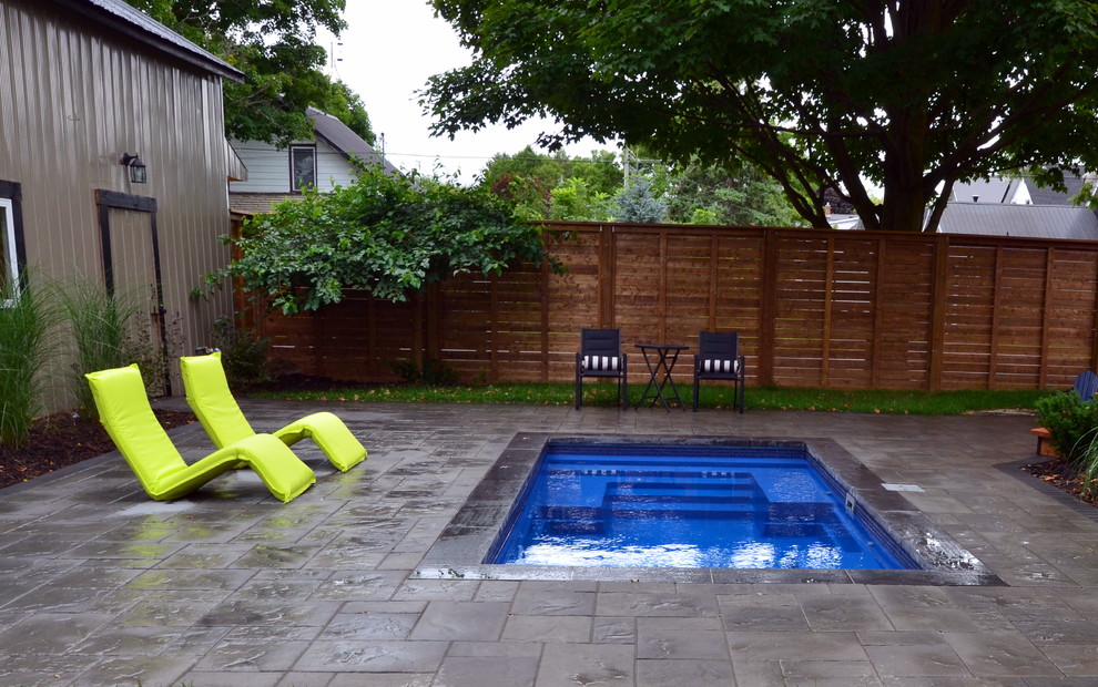 Imagen de piscina contemporánea pequeña rectangular en patio trasero con adoquines de hormigón