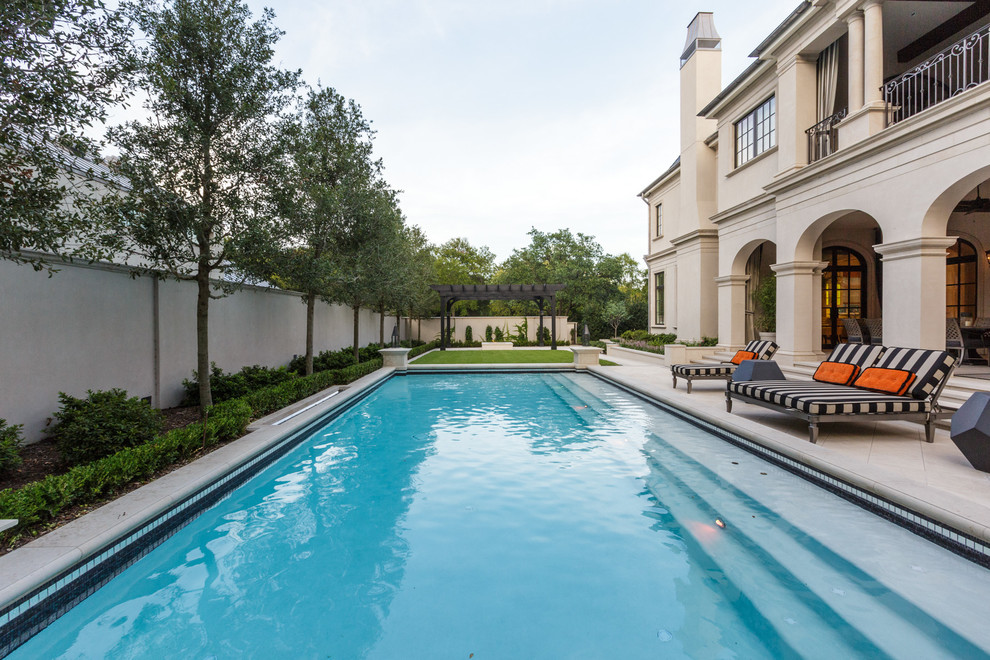Diseño de casa de la piscina y piscina alargada mediterránea rectangular en patio trasero con suelo de hormigón estampado