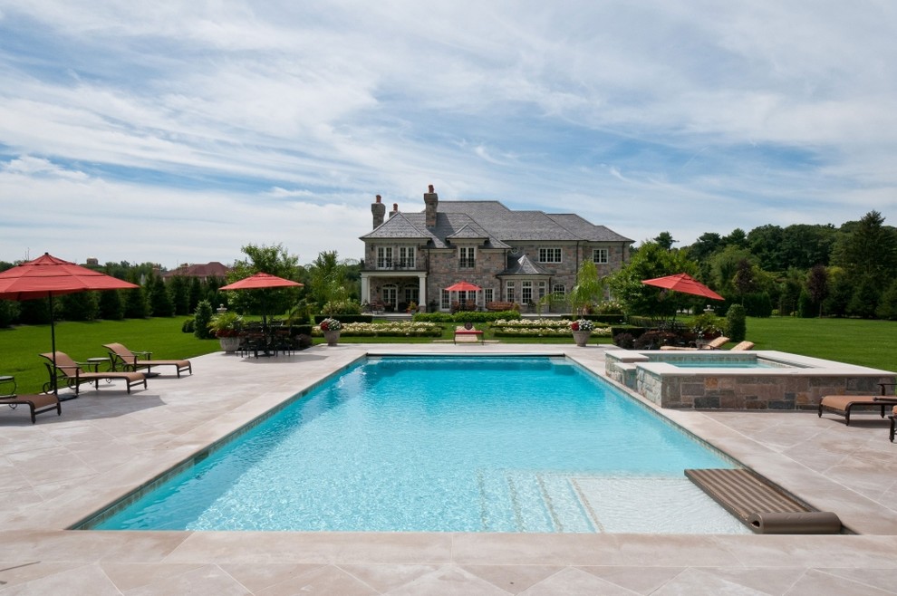 Стильный дизайн: большой прямоугольный бассейн на заднем дворе в классическом стиле с джакузи и покрытием из каменной брусчатки - последний тренд
