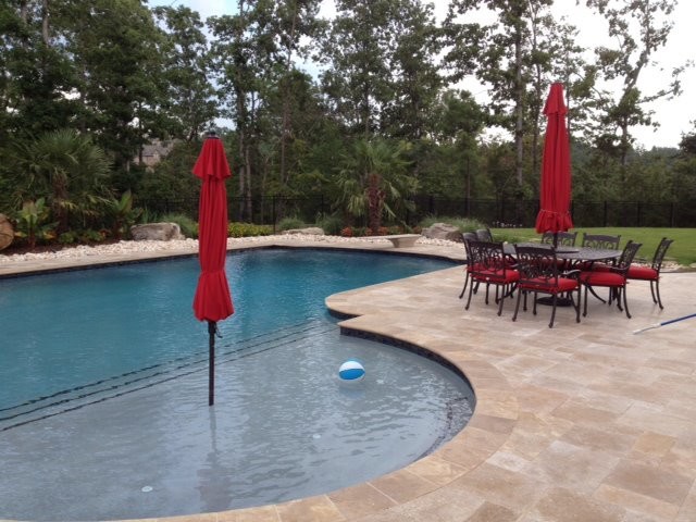 Esempio di una grande piscina classica personalizzata dietro casa con pavimentazioni in pietra naturale