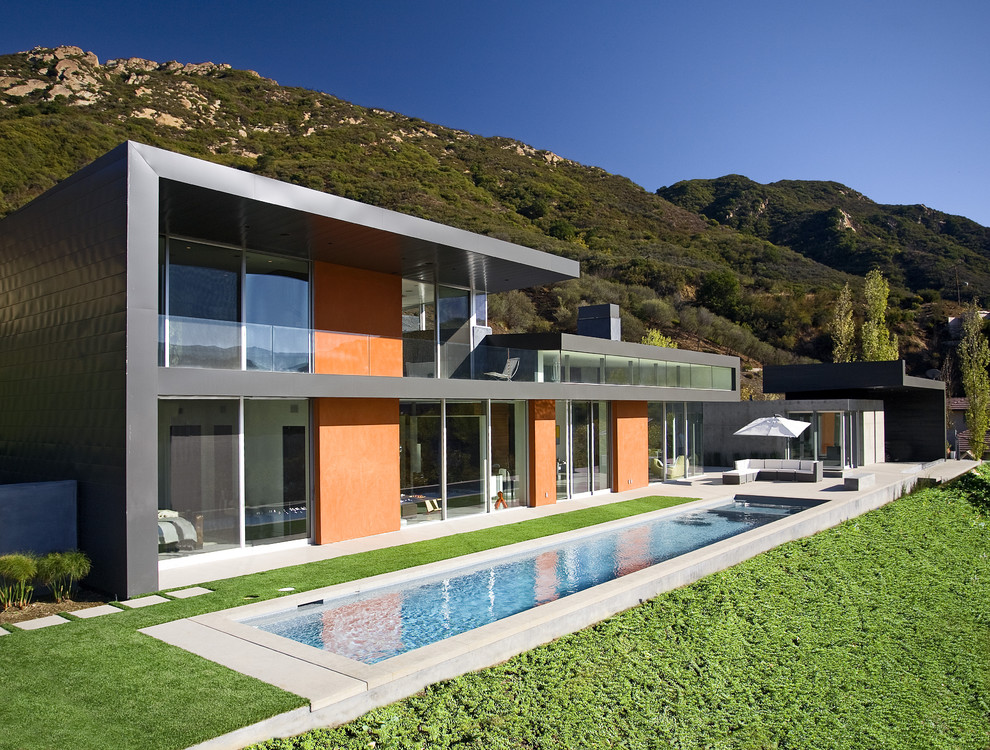 Foto di una grande piscina monocorsia minimalista rettangolare dietro casa con lastre di cemento