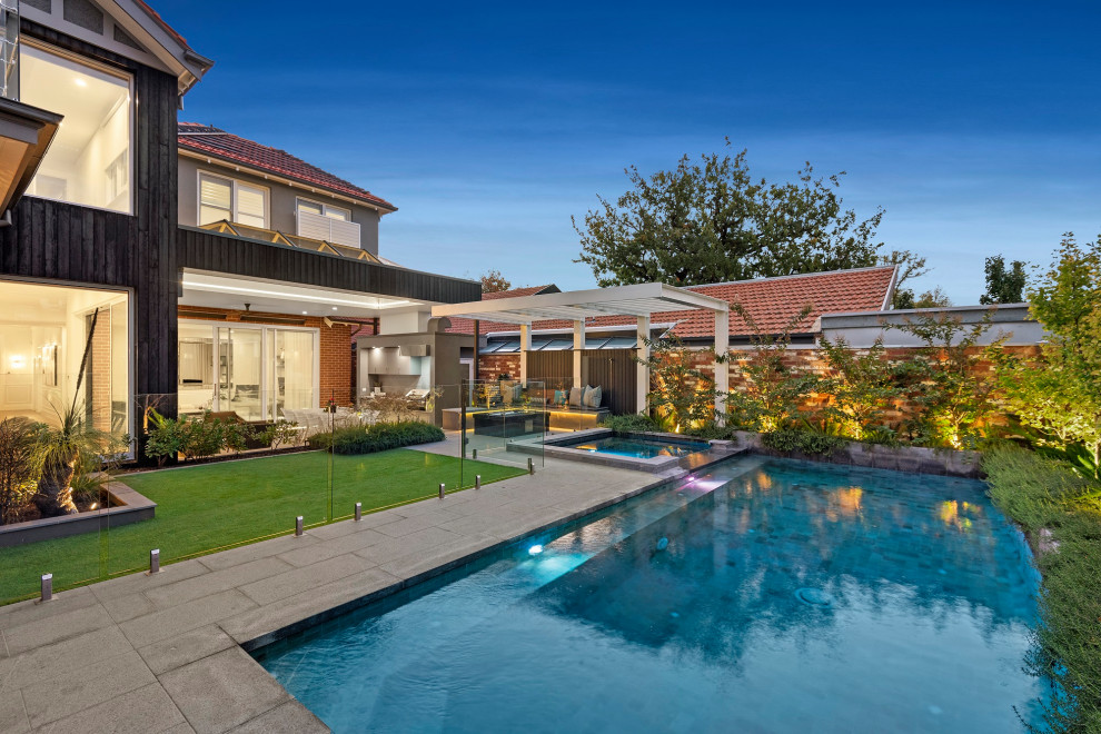 Стильный дизайн: прямоугольный бассейн среднего размера на заднем дворе в викторианском стиле с джакузи и мощением тротуарной плиткой - последний тренд