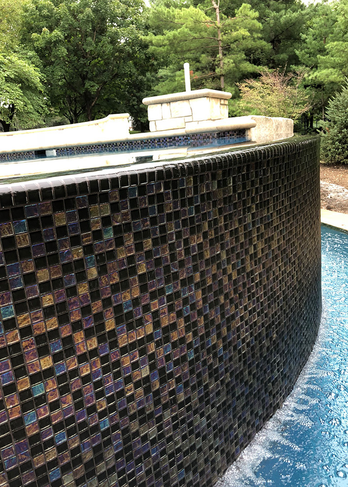 Backyard stone and custom-shaped infinity hot tub photo in Omaha