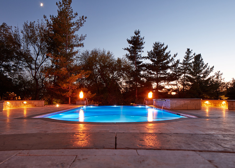 Идея дизайна: бассейн-инфинити произвольной формы на заднем дворе с джакузи и покрытием из каменной брусчатки