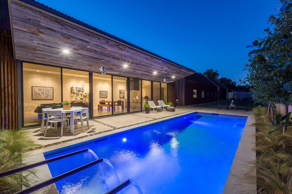 Immagine di una piccola piscina minimalista rettangolare dietro casa con lastre di cemento