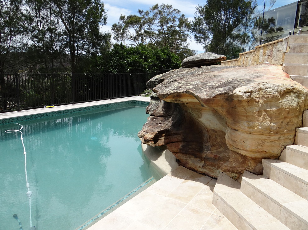 Idee per una piscina fuori terra chic personalizzata di medie dimensioni e dietro casa con fontane e pavimentazioni in pietra naturale