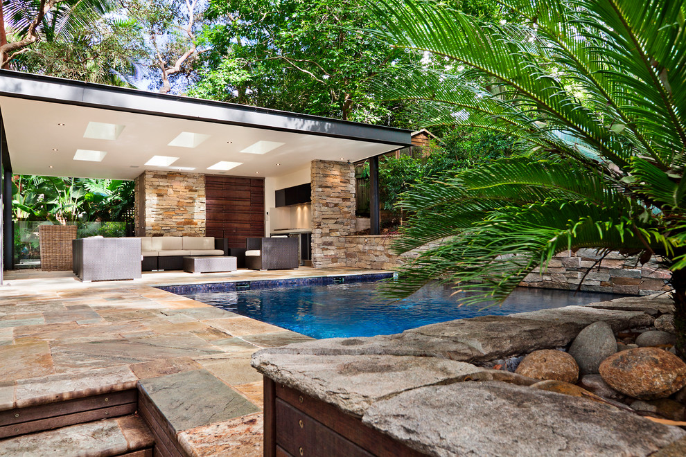 Пример оригинального дизайна: бассейн среднего размера, произвольной формы на заднем дворе в современном стиле с покрытием из каменной брусчатки