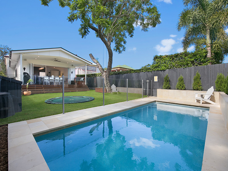 Esempio di una piscina naturale design rettangolare di medie dimensioni e dietro casa con pavimentazioni in pietra naturale