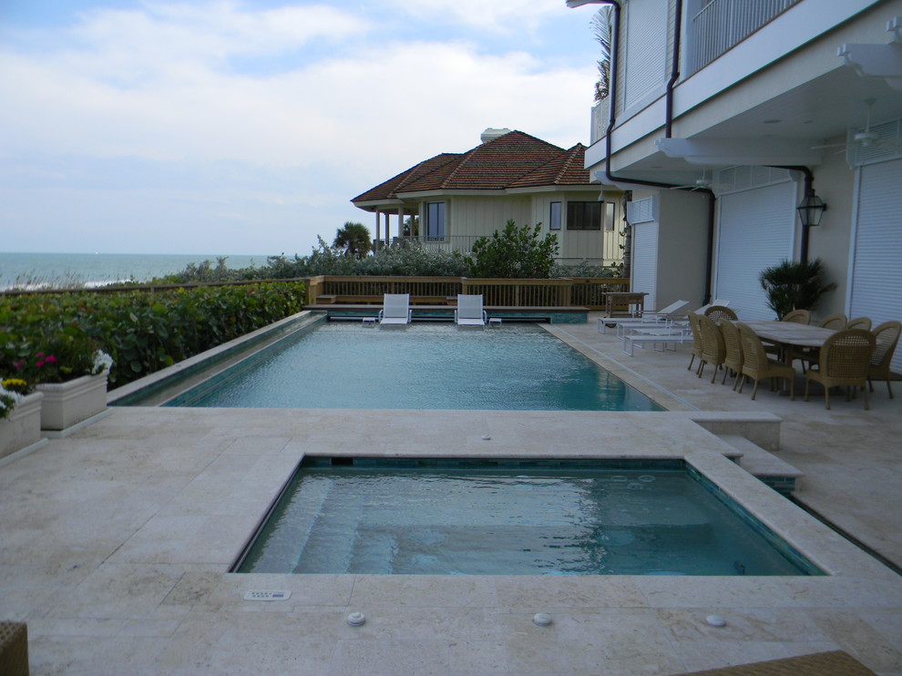 Ispirazione per una grande piscina monocorsia contemporanea personalizzata dietro casa con pavimentazioni in pietra naturale