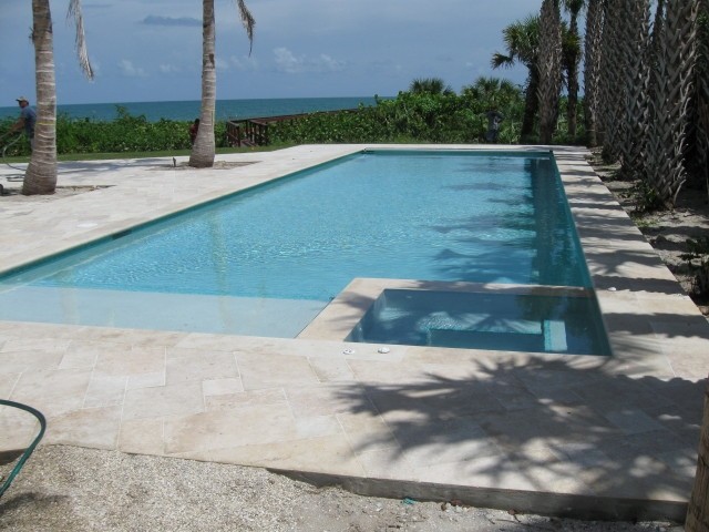 Großer Moderner Pool hinter dem Haus in rechteckiger Form mit Natursteinplatten in Miami
