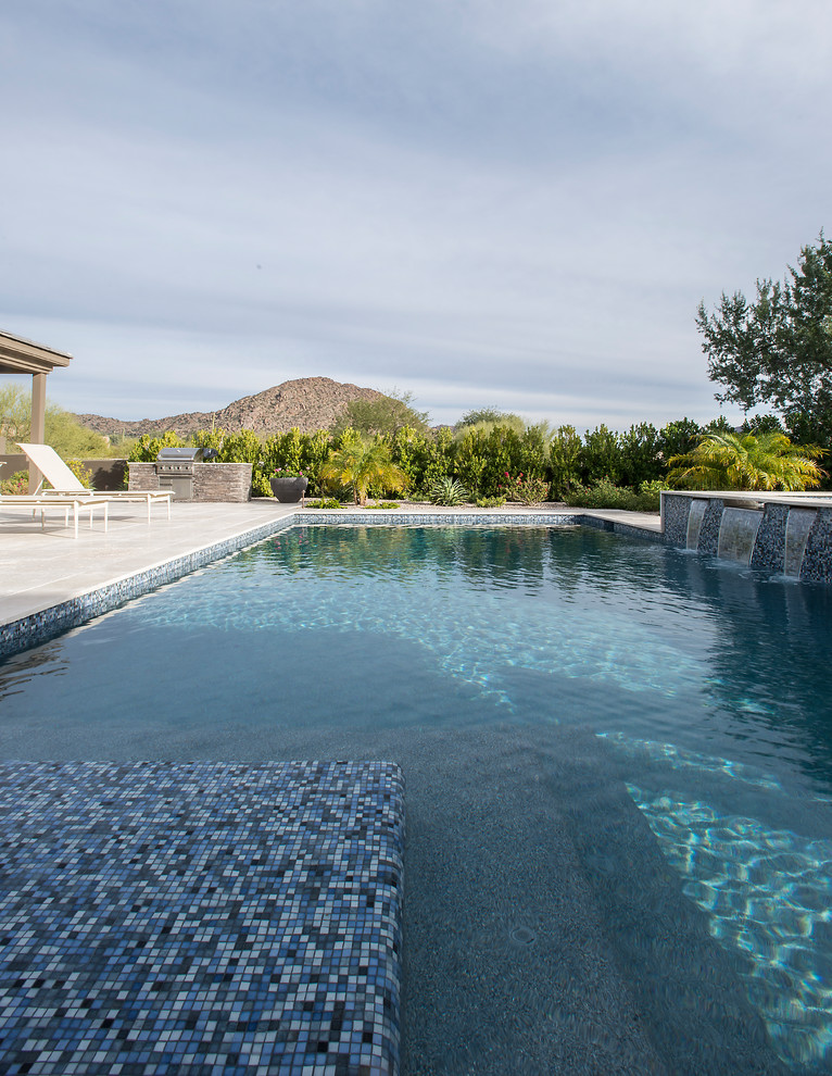 Ejemplo de piscinas y jacuzzis modernos grandes rectangulares en patio trasero con adoquines de piedra natural