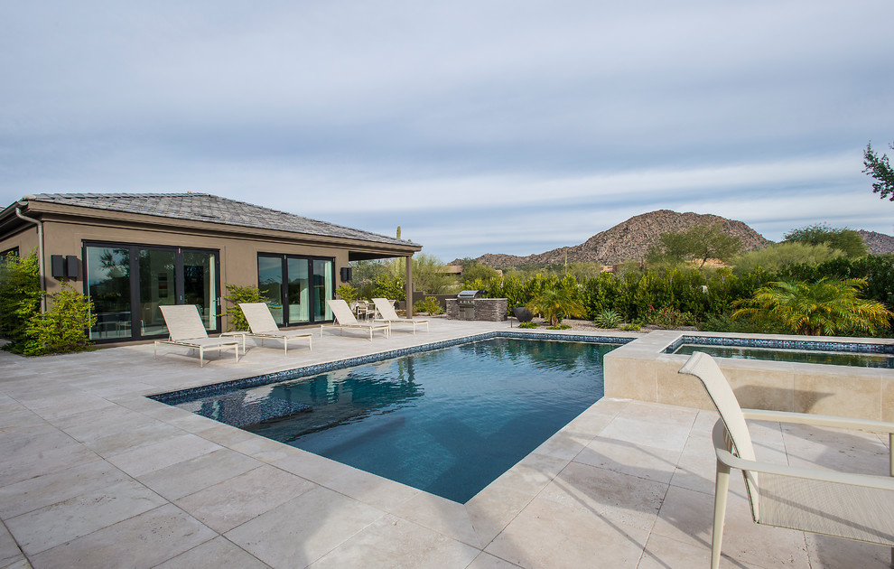 На фото: большой прямоугольный бассейн на заднем дворе в стиле модернизм с джакузи и покрытием из каменной брусчатки