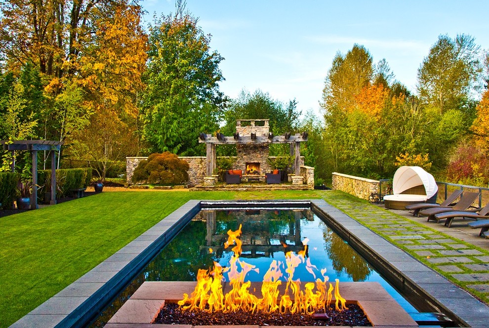 Imagen de piscinas y jacuzzis rústicos grandes rectangulares en patio trasero con adoquines de piedra natural