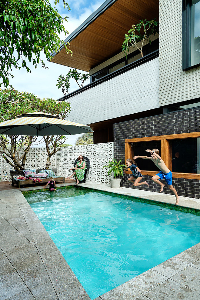 Modelo de piscina alargada retro de tamaño medio rectangular en patio trasero