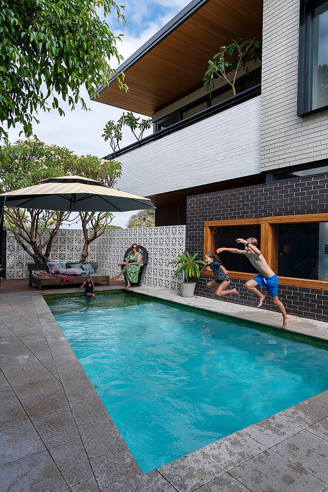 Idee per una piscina monocorsia minimalista rettangolare di medie dimensioni e dietro casa