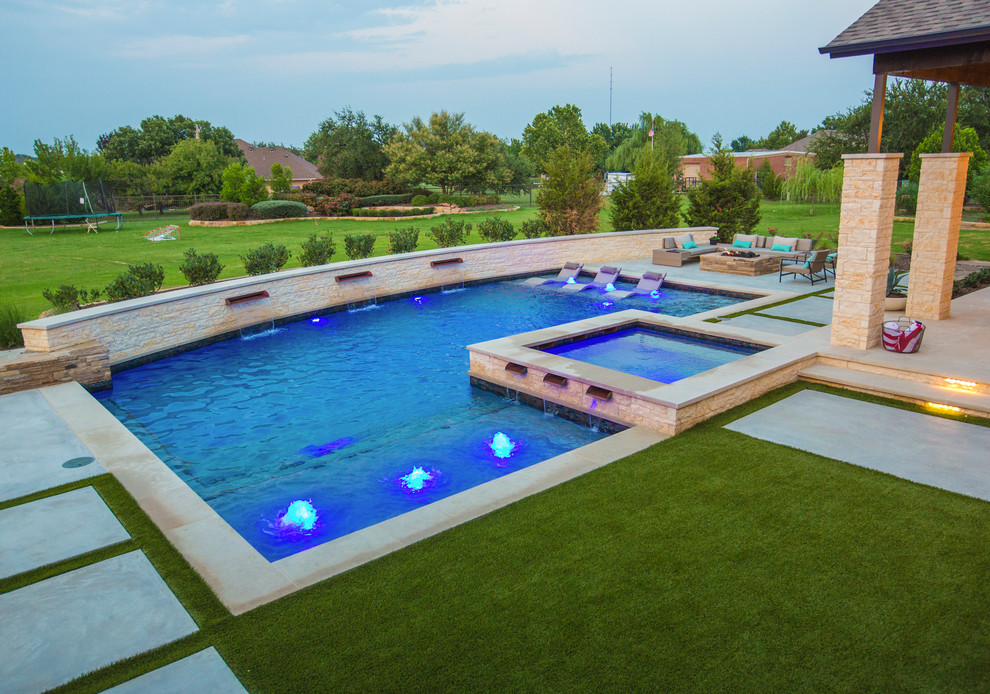 Modelo de piscina actual grande en forma de L en patio trasero con losas de hormigón