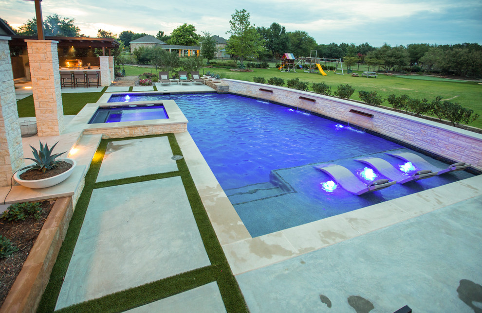 Exemple d'une grande piscine arrière tendance en L avec une dalle de béton.