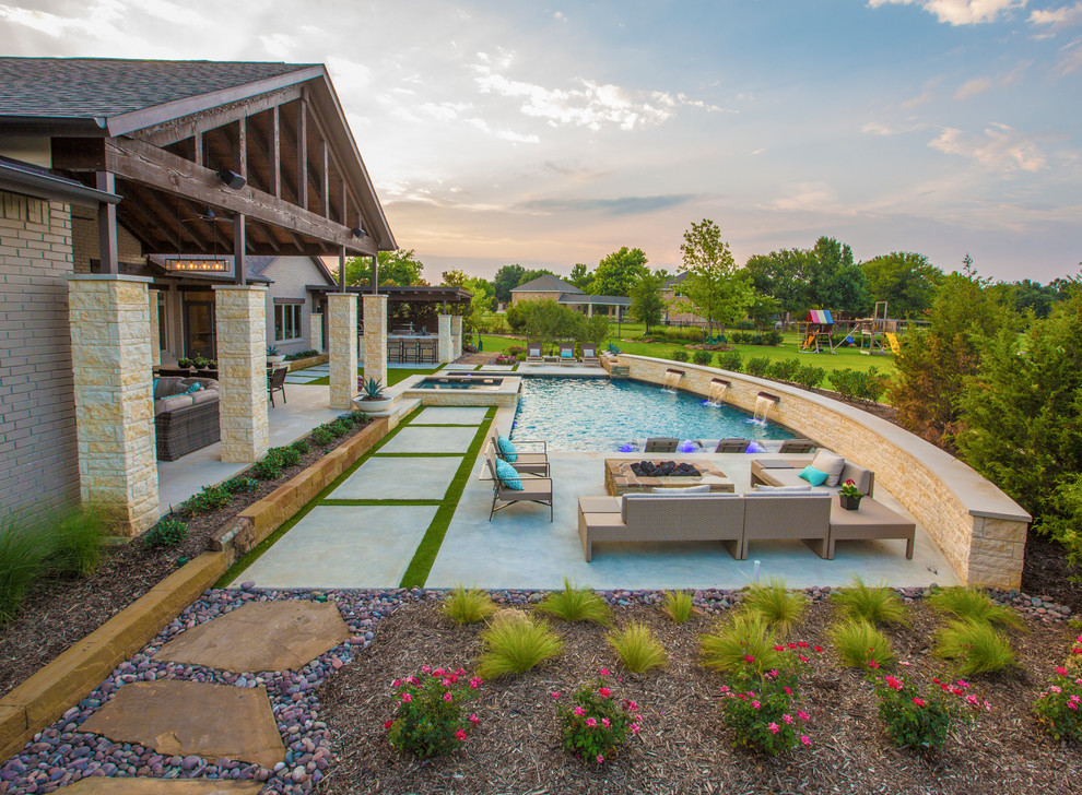 Großer Moderner Pool hinter dem Haus in L-Form mit Wasserspiel in Dallas