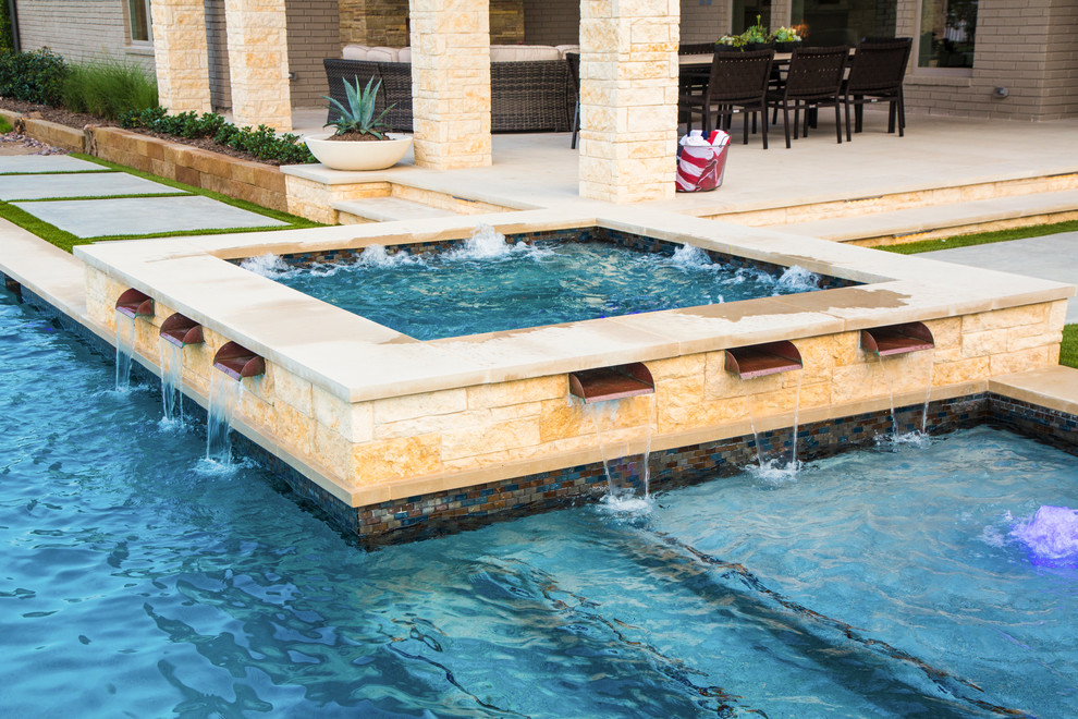 На фото: большой угловой бассейн на заднем дворе в стиле неоклассика (современная классика) с фонтаном и покрытием из бетонных плит с