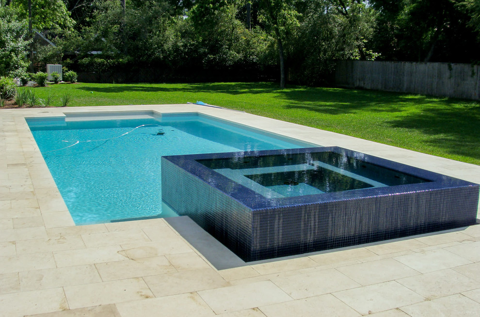 Example of a mid-sized trendy backyard stone and rectangular pool fountain design in Houston