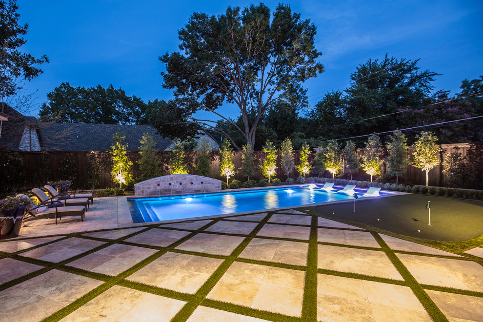 Réalisation d'une piscine arrière méditerranéenne de taille moyenne et rectangle avec des pavés en pierre naturelle.