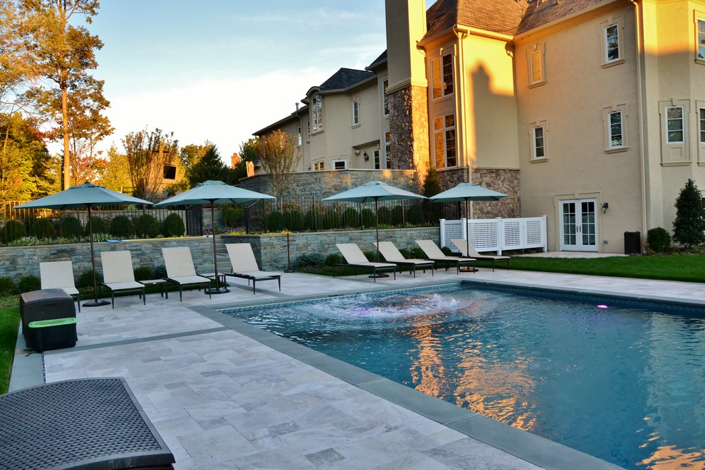 Modelo de piscinas y jacuzzis alargados contemporáneos extra grandes rectangulares en patio trasero con adoquines de hormigón